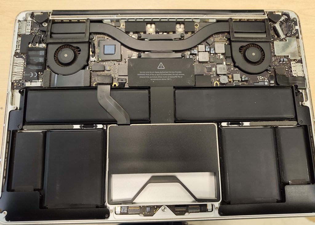 Vista interna de un MacBook Pro A1425 mostrando la disposición de la batería y ventiladores.