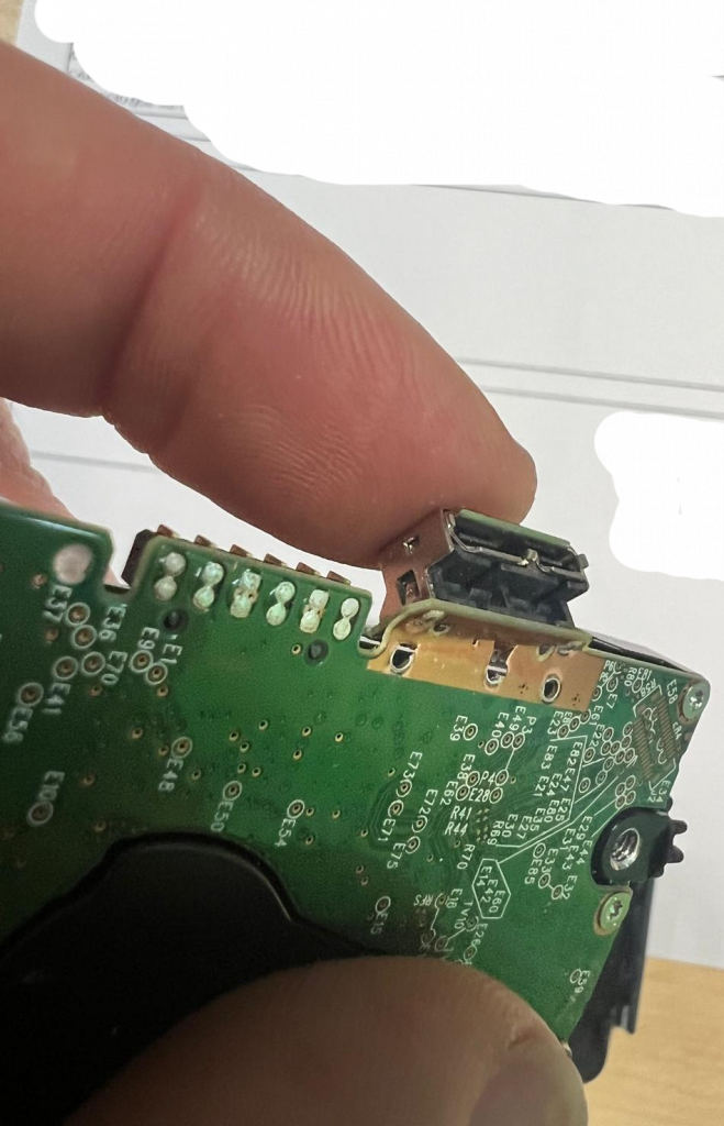 Detalle de conector Micro-B USB 3.0 roto con pads de soldadura dañados.