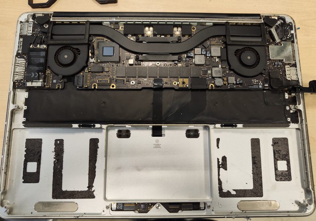 Chasis del MacBook Pro sin batería, mostrando las marcas del adhesivo industrial.