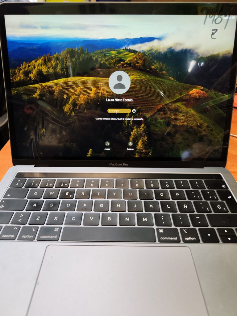 MacBook Pro 13 2018 reparado con éxito, mostrando imagen nítida en la pantalla de inicio de sesión de macOS.