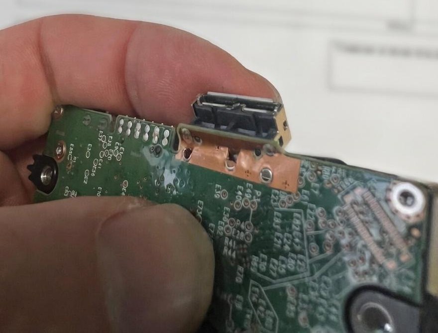 Close-up de la PCB mostrando las pistas de datos arrancadas que requieren micro-soldadura. | everpc.net