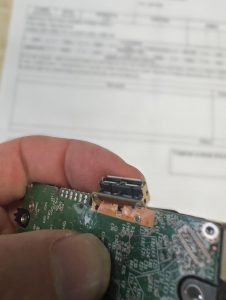 Close-up de la PCB mostrando las pistas de datos arrancadas que requieren micro-soldadura.