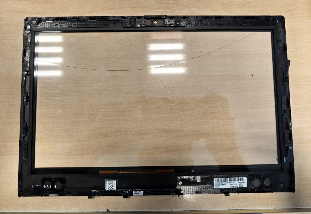 Parte trasera del panel táctil mostrando el cable flex y el número de serie de la pieza.