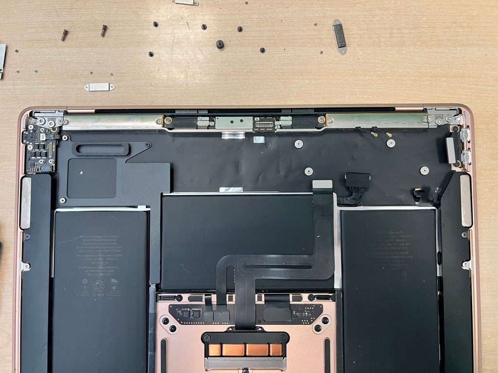 Proceso de desmontaje de la placa base dañada en MacBook Air M1.