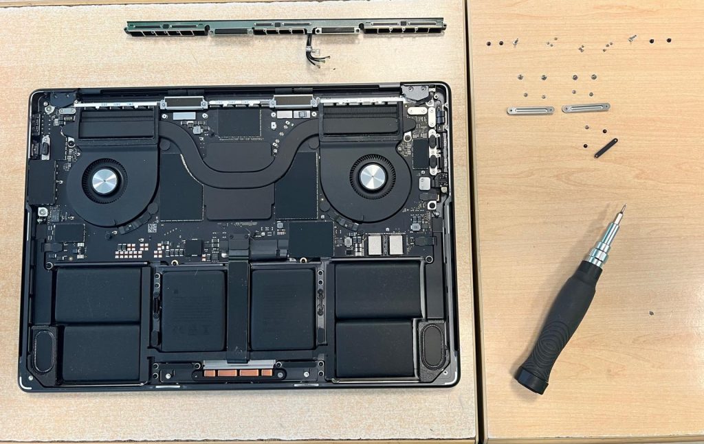Proceso de apertura con herramientas de precisión y organización de tornillería técnica.