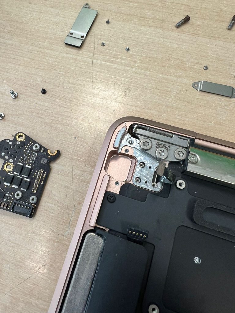 Primer plano del módulo de puertos USB-C y conectores internos de MacBook.