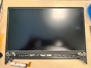Proceso de colocación del nuevo panel de pantalla en la estructura de la tapa.