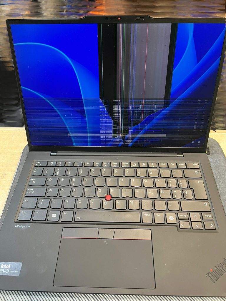 Lenovo ThinkPad X1 Carbon Gen 12 con pantalla dañada mostrando líneas verticales y manchas negras.