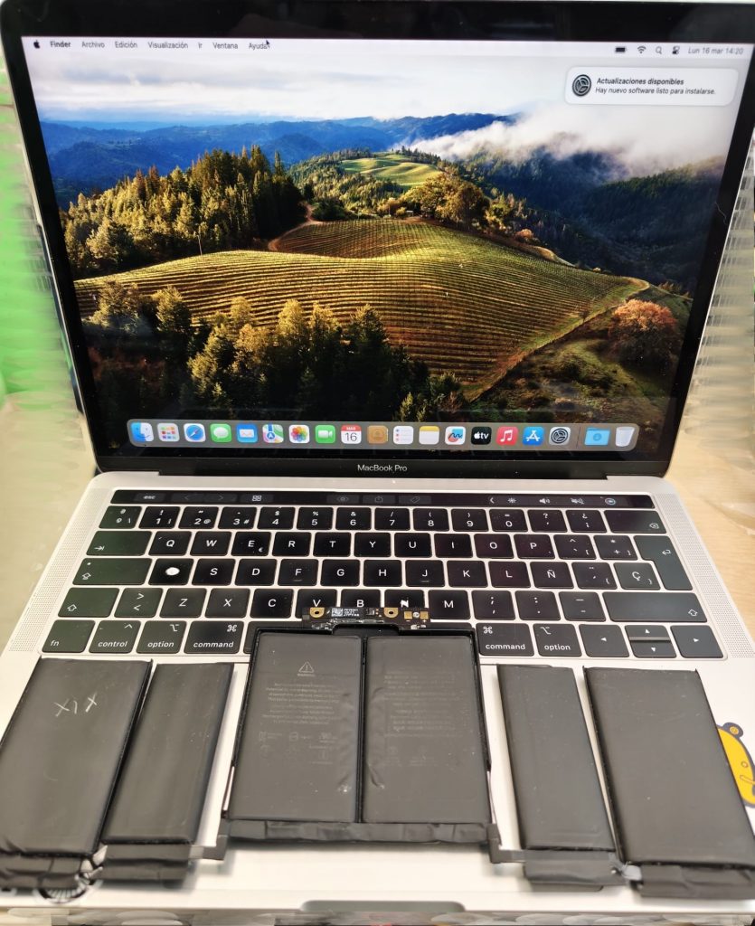 MacBook Pro A1989 encendido con la batería vieja e hinchada retirada sobre el teclado.