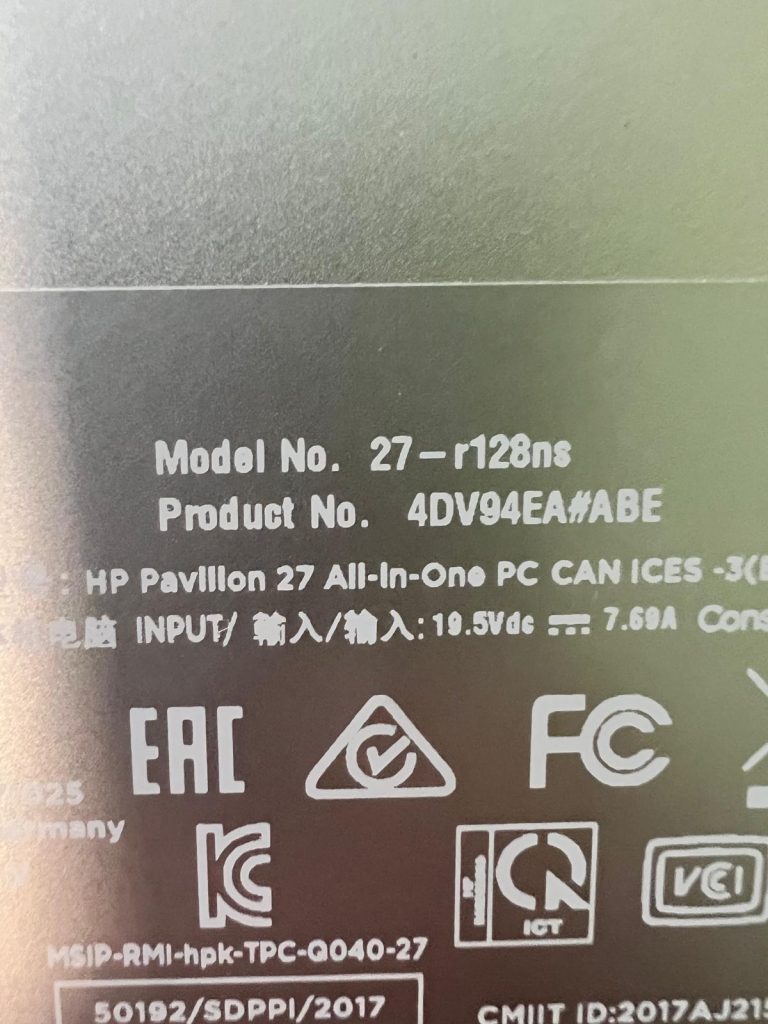 Etiqueta trasera con el número de modelo 27-r128ns y especificaciones eléctricas de HP.