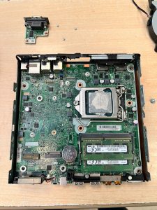 Vista detallada de la placa base defectuosa dentro del chasis del mini PC.