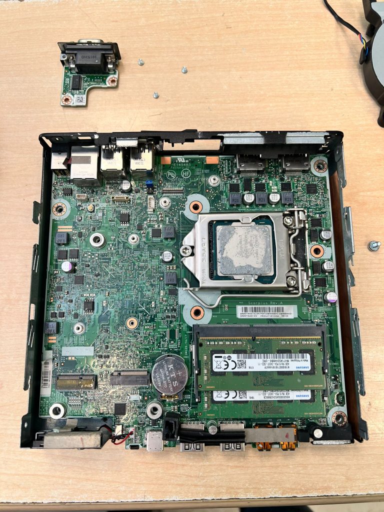 Vista detallada de la placa base defectuosa dentro del chasis del mini PC.