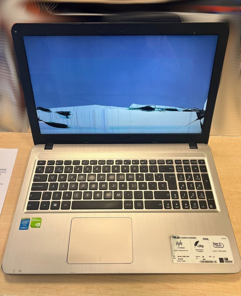 Portátil Asus F540L con pantalla LCD rota mostrando manchas negras y líneas de colores.