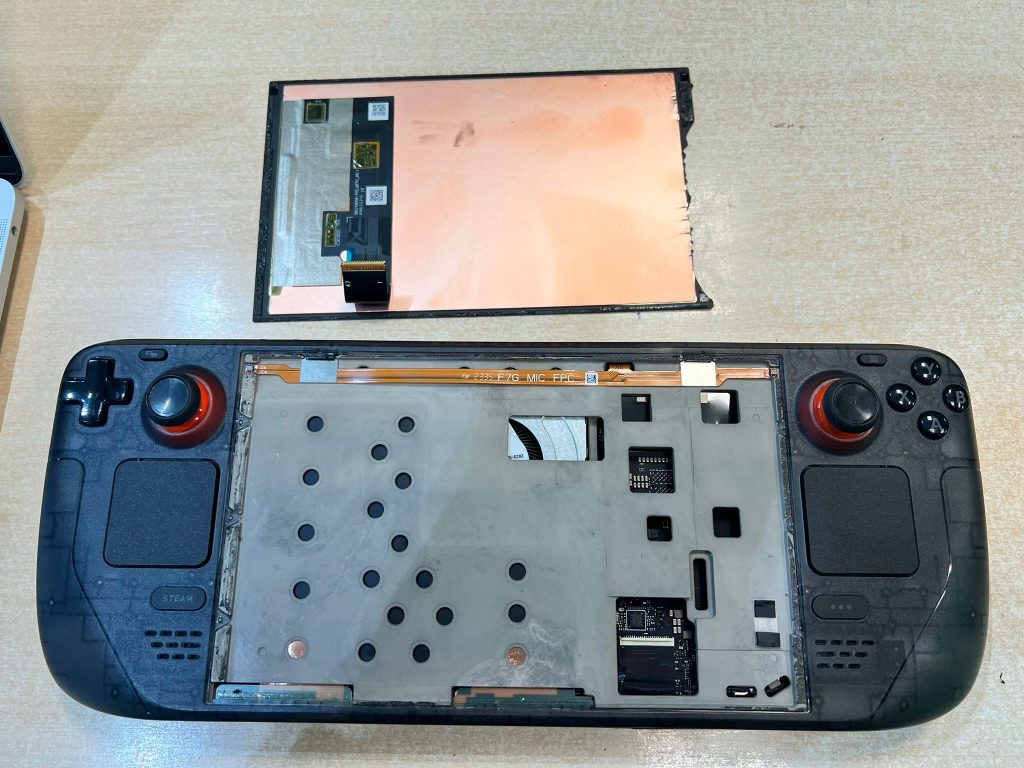 Primer plano de la etiqueta trasera de una Valve Steam Deck donde se lee Model 1030, fabricada por Valve Corporation, mostrando certificaciones de seguridad.