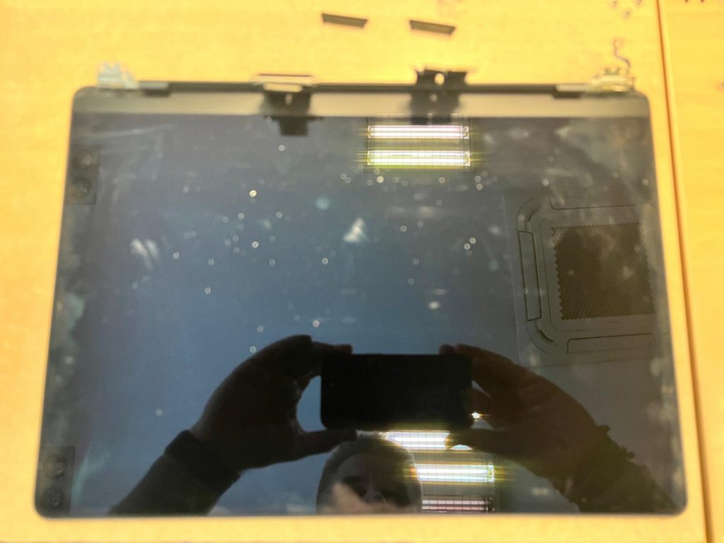 La pantalla dañada ha sido completamente removida del chasis de aluminio.