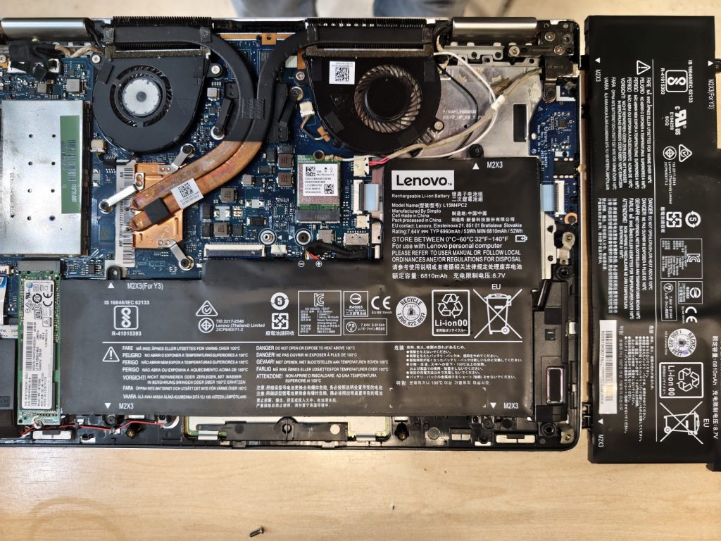 Vista interna de la laptop mostrando la batería original con una hinchazón severa y peligrosa.