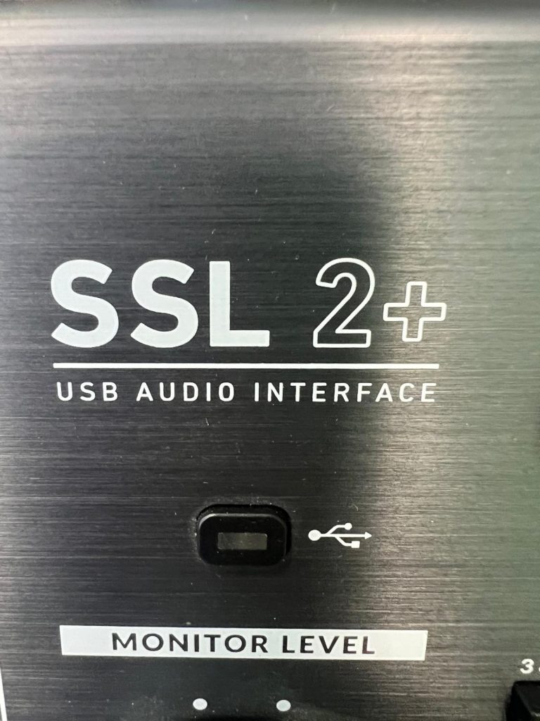 Primer plano del panel frontal de la SSL 2+ destacando el área de conexión USB.
