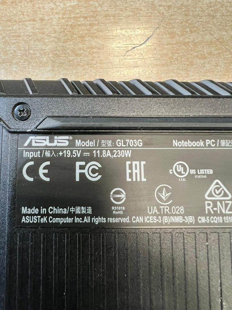Etiqueta técnica del modelo Asus GL703G detallando entrada de corriente de 19.5V y 230W.