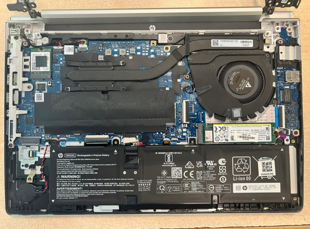 Vista interna de HP ProBook 440 G10: batería RH03XL, ventilador y placa base.