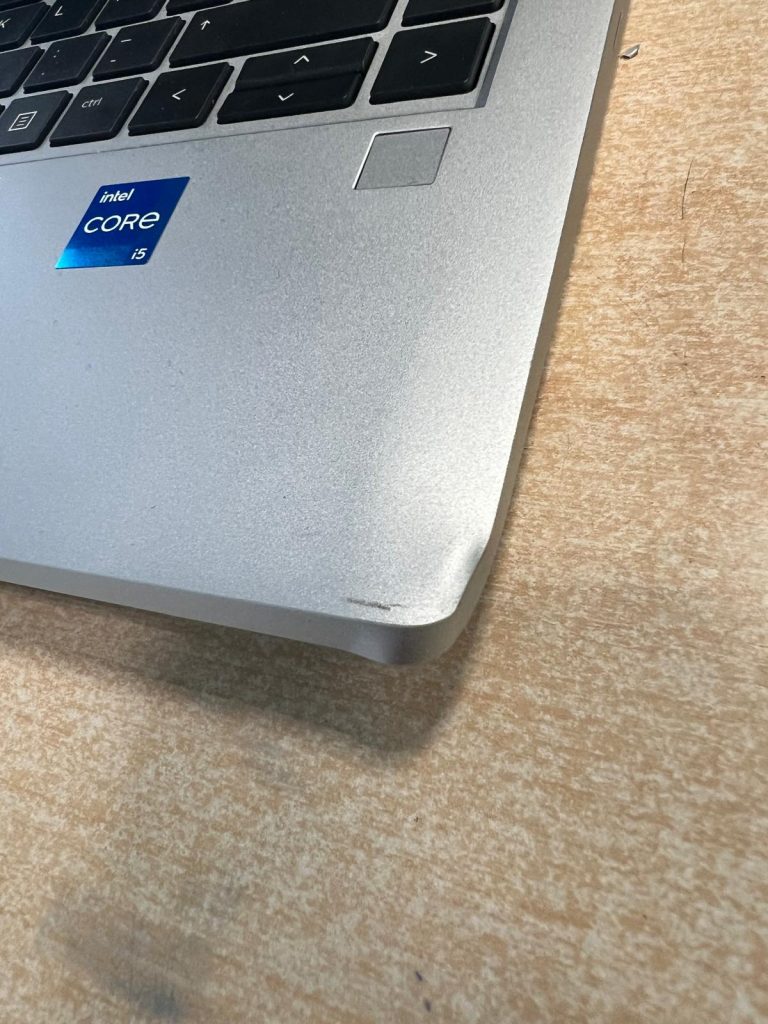 Detalle de abolladura y raspadura en la esquina del palmrest de un HP ProBook 440 G10.