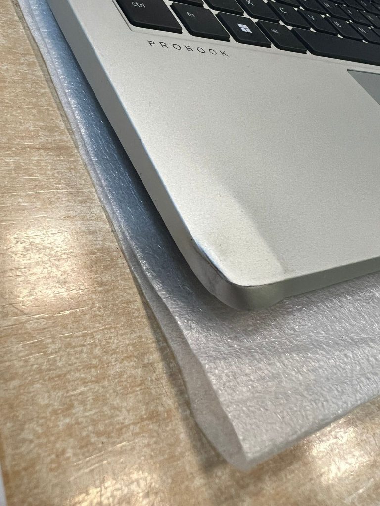 Detalle del daño estético y deformación en la esquina del chasis de un HP ProBook 440 G10.