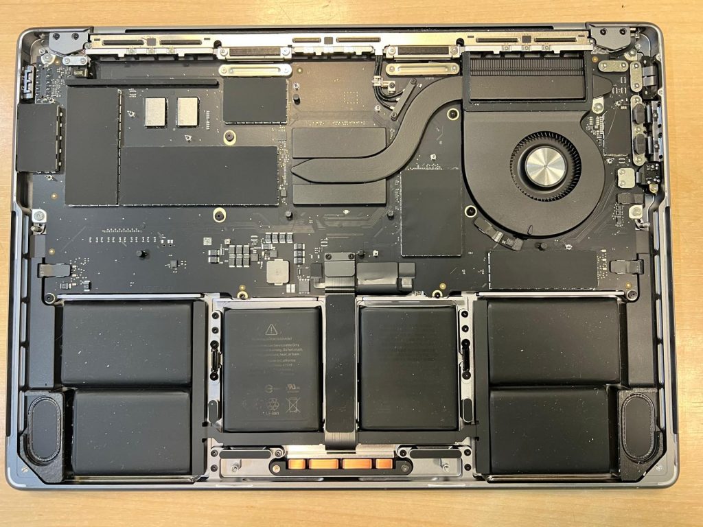 Vista interna de los componentes, batería y placa base de una MacBook Pro A2918.