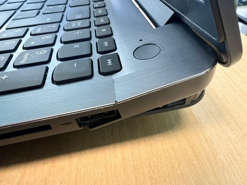 Daño estructural en bisagra de laptop Lenovo provocando apertura del chasis lateral.