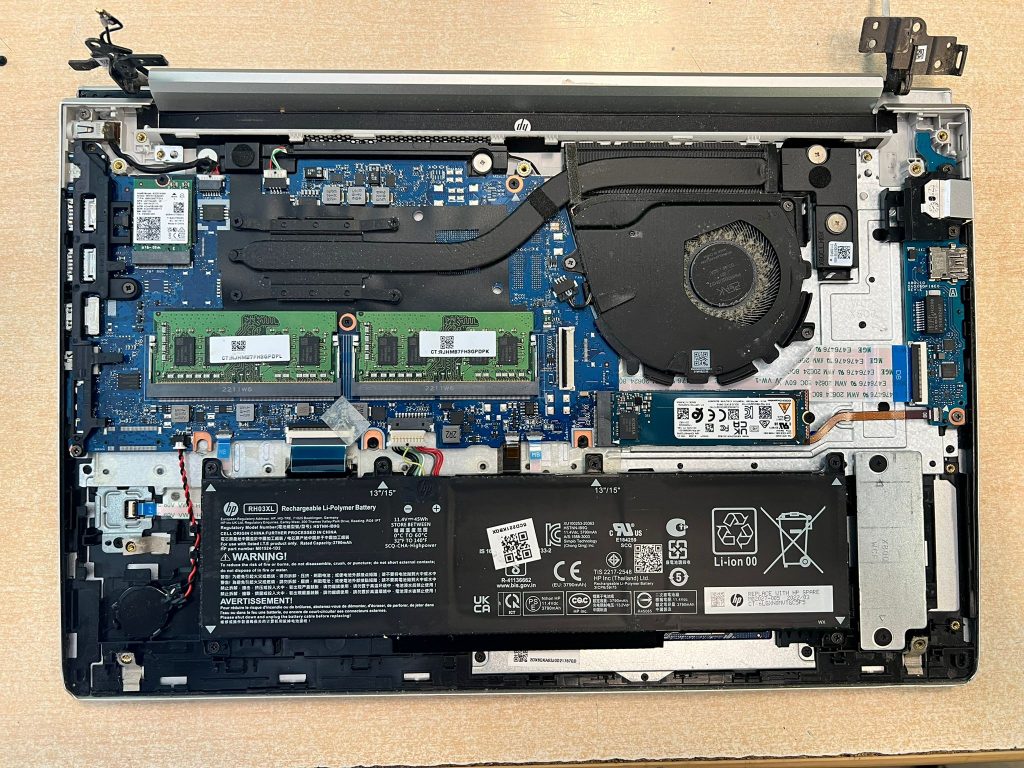 Vista interna del HP ProBook mostrando ventilador obstruido por polvo y componentes.