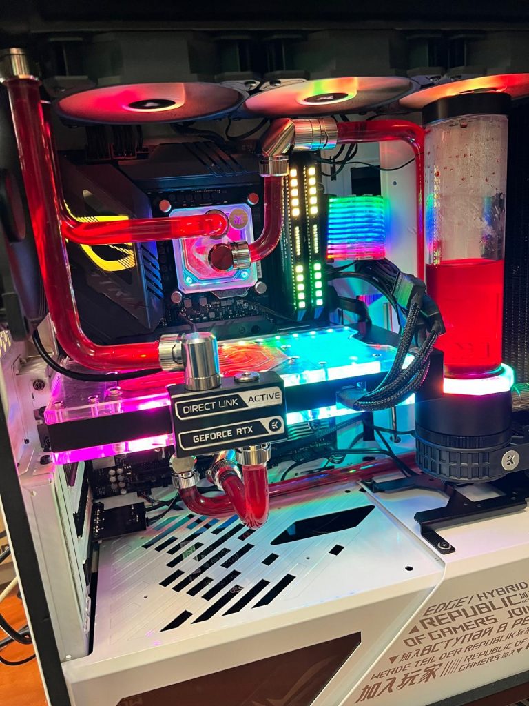 Ensamble completo de refrigeración líquida custom con iluminación RGB y líquido rojo.