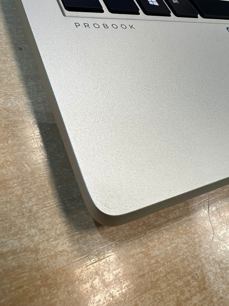 Zoom del impacto en la carcasa de aluminio de un portátil HP ProBook.