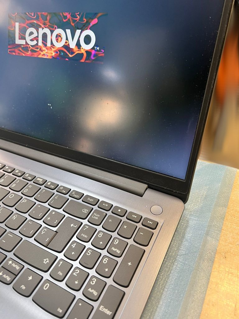 Laptop Lenovo IdeaPad 3 encendida y totalmente restaurada tras el cambio de teclado y chasis.