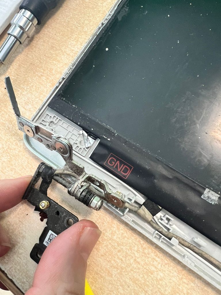 Primer plano de los anclajes de plástico destruidos en la tapa trasera del HP.