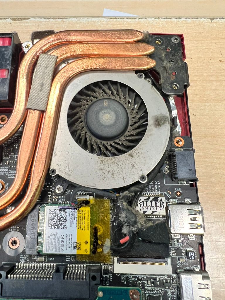 Detalle de ventilador de laptop MSI obstruido por polvo y pelusa acumulada.