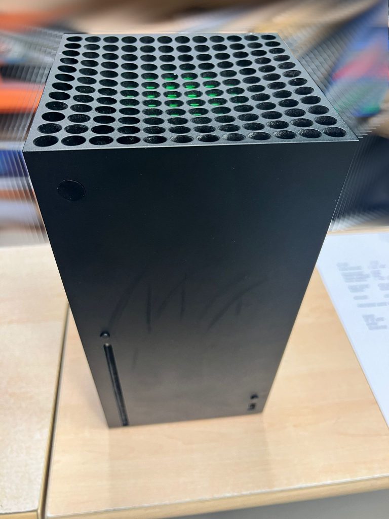 Vista exterior frontal de una consola Xbox Series X para reparación.