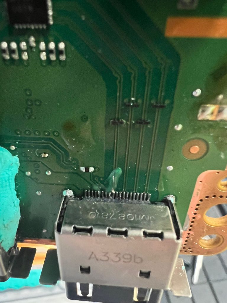 Close-up del puerto HDMI roto de Xbox Series X mostrando pines doblados.