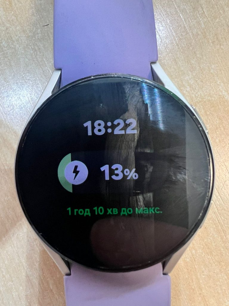 Prueba de carga del smartwatch Samsung mostrando 13% de batería y tiempo estimado de carga.