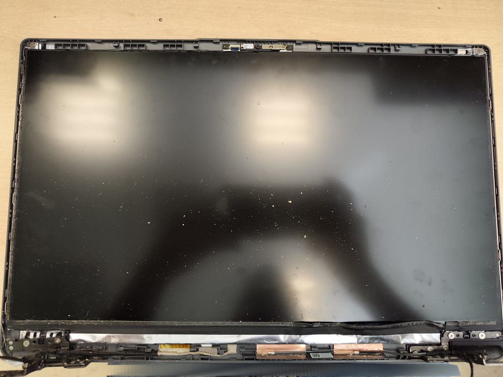 Proceso de desmontaje del panel de pantalla LCD para acceder a la carcasa trasera.