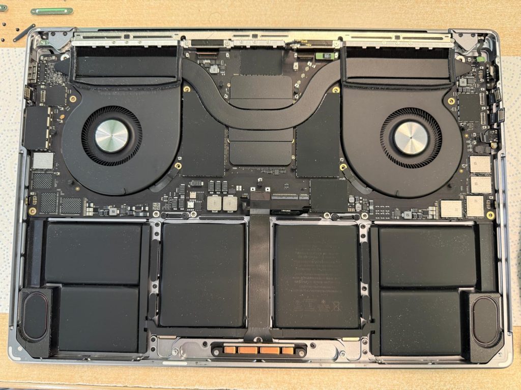 Proceso de desconexión de flexores y componentes internos en MacBook Pro 2021.