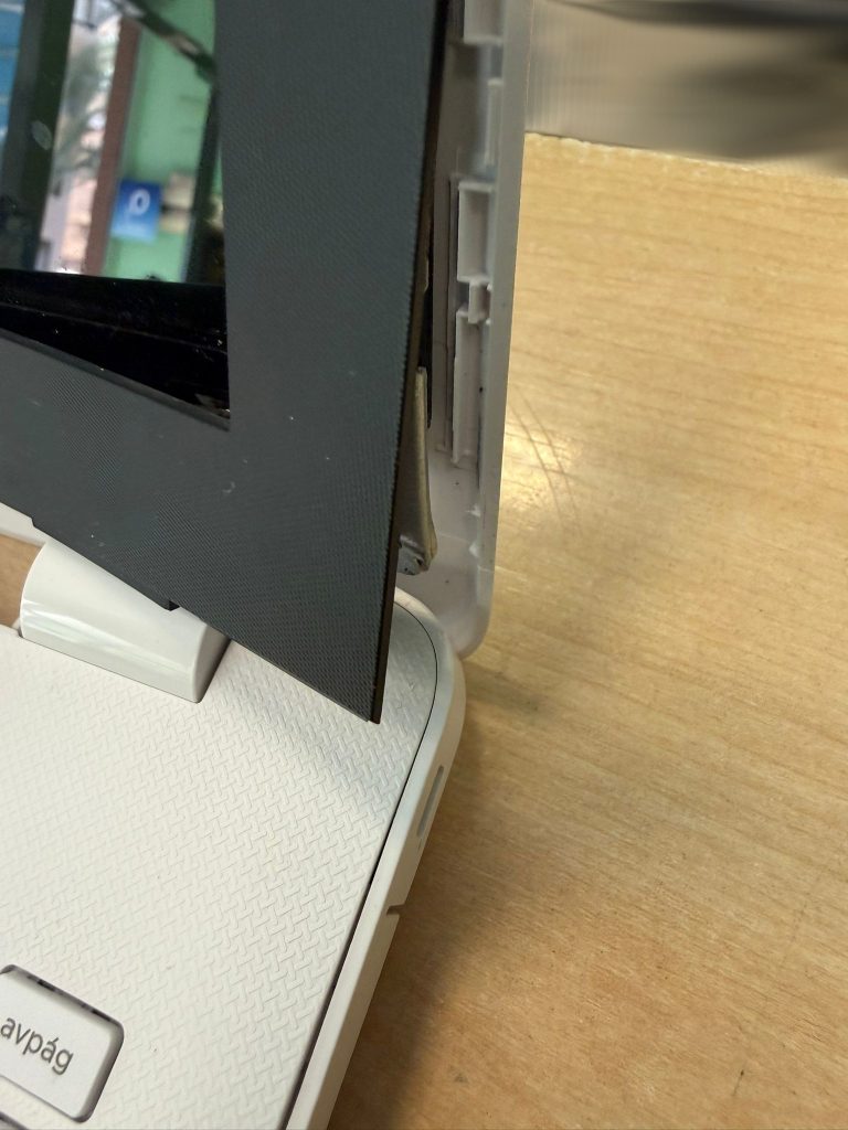 Detalle del marco de la pantalla separado debido a la rotura de la bisagra en HP 15-bs.