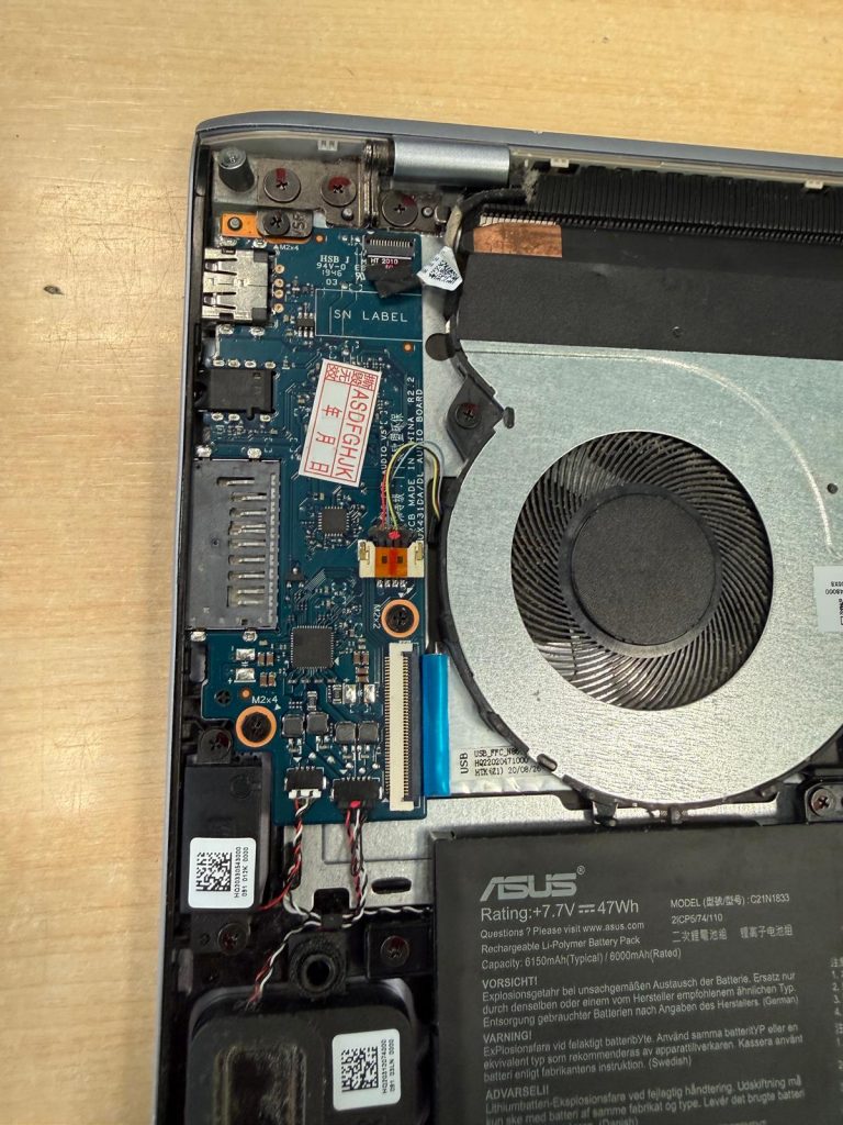 Primer plano de la subplaca lateral y conexiones en Asus UM431D.