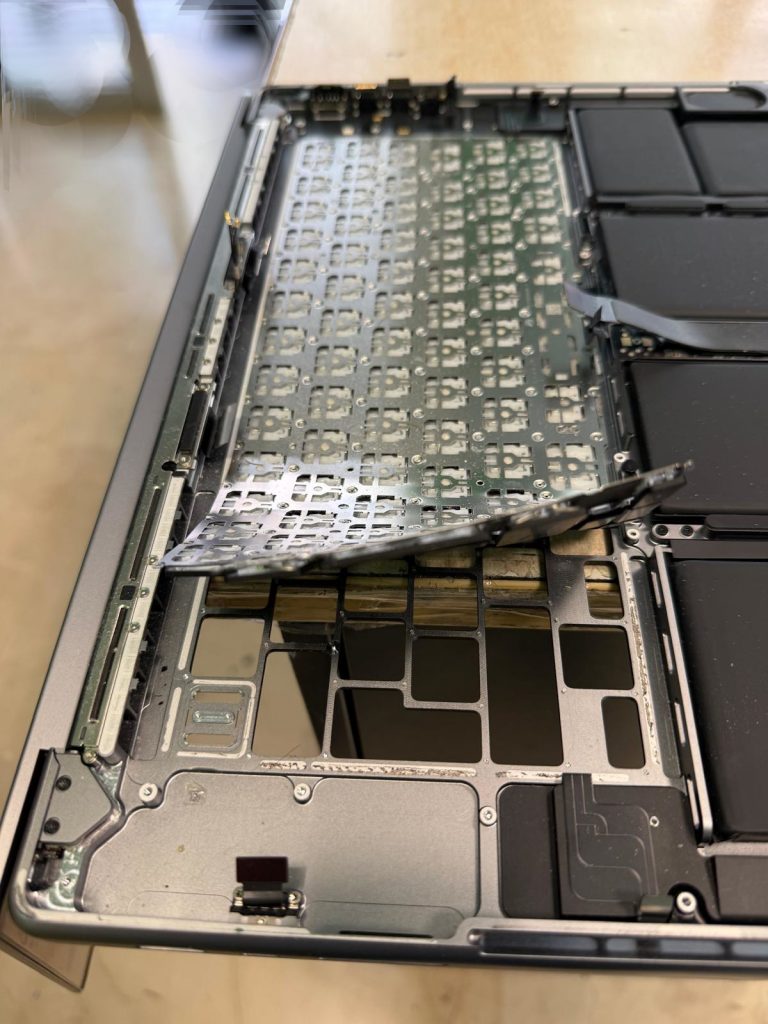 Extracción manual del teclado antiguo del cuerpo de aluminio de la MacBook Pro.