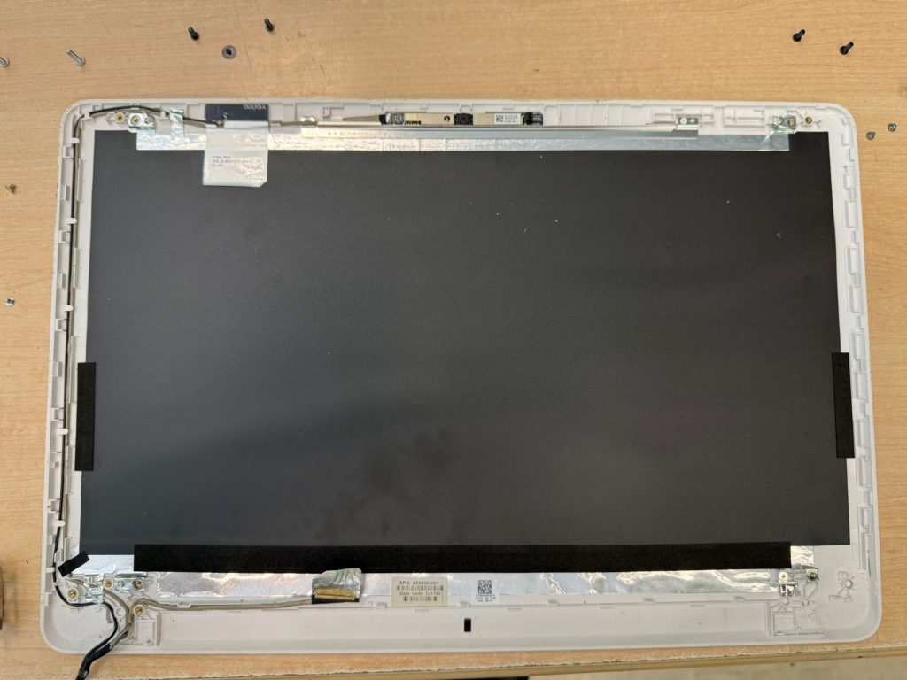 Proceso de desmontaje del panel LCD para acceder a los soportes de la bisagra.