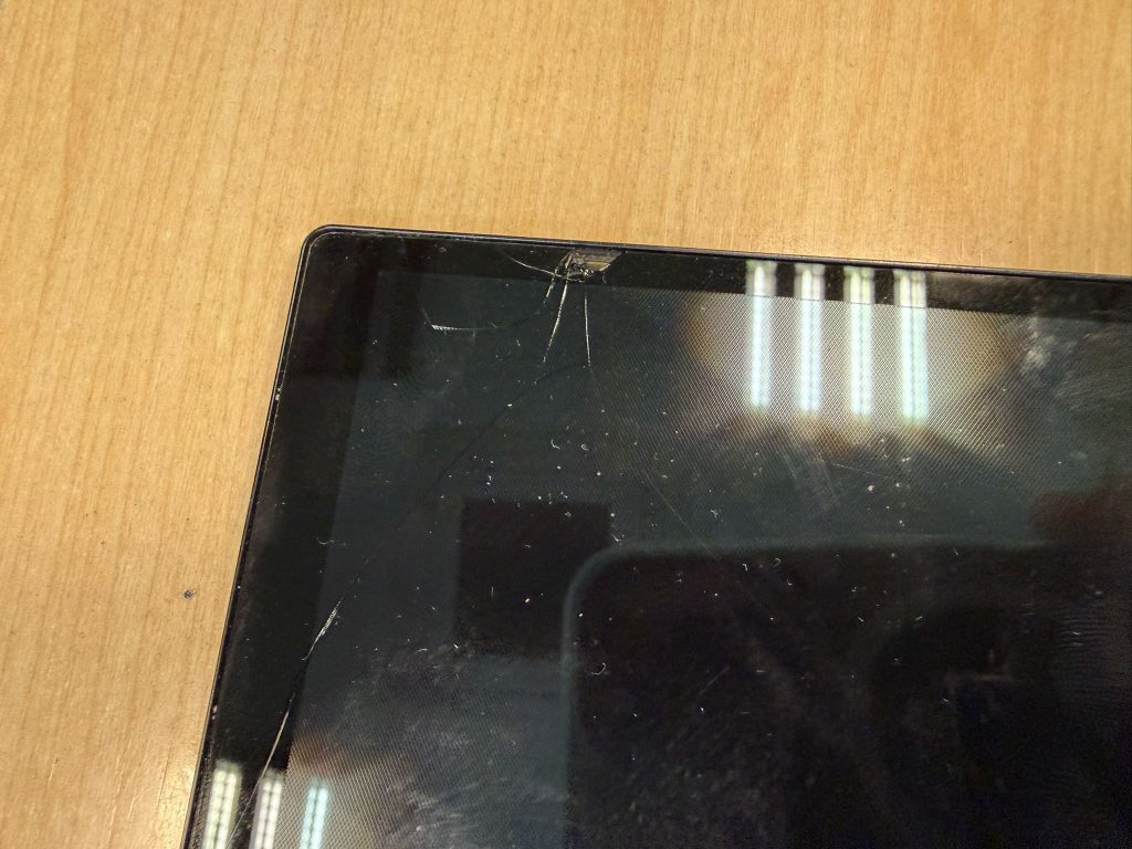 Detalle de la esquina superior de la pantalla táctil rota del Lenovo ThinkPad X1 Yoga Gen 5.