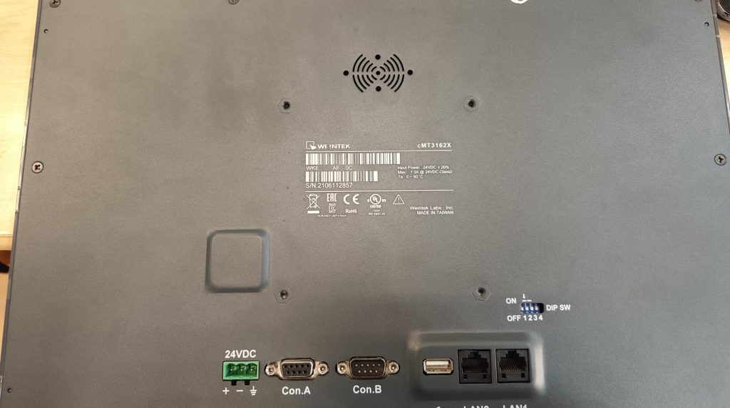 Tapa trasera del HMI cMT3162X mostrando conectores 24VDC, Con.A, Con.B y puertos LAN.