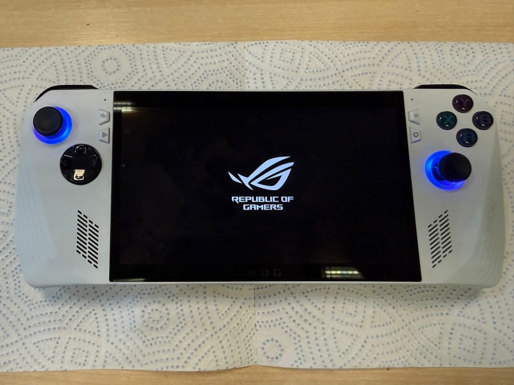 Consola ROG Ally encendida mostrando el logo de Republic of Gamers tras la reparación.