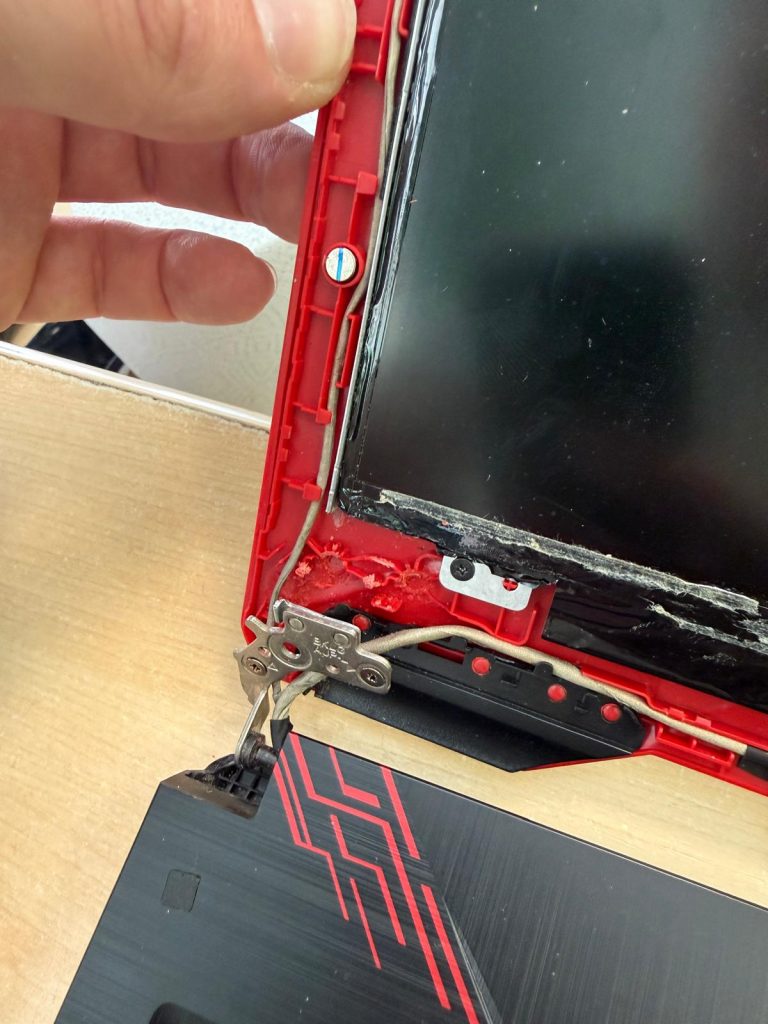 Vista interna de la tapa roja del Asus FX504G con postes de tornillo de bisagra arrancados.