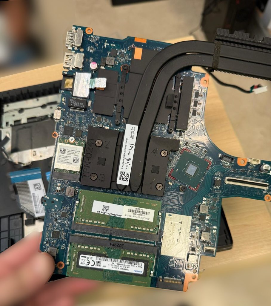écnico retirando la placa base dañada modelo TPN-Q241 del chasis.