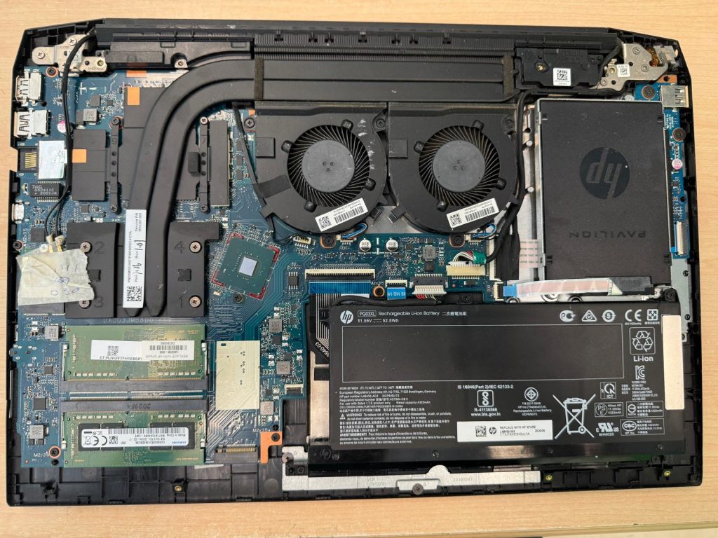 Desmontaje inicial del HP Pavilion Gaming 16 mostrando batería, ventiladores y placa base.