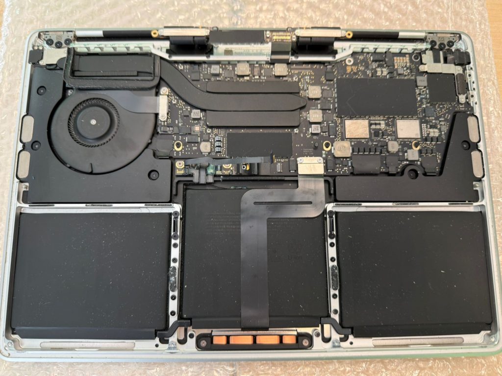 Vista interna de MacBook Pro A2289 mostrando placa base y batería.