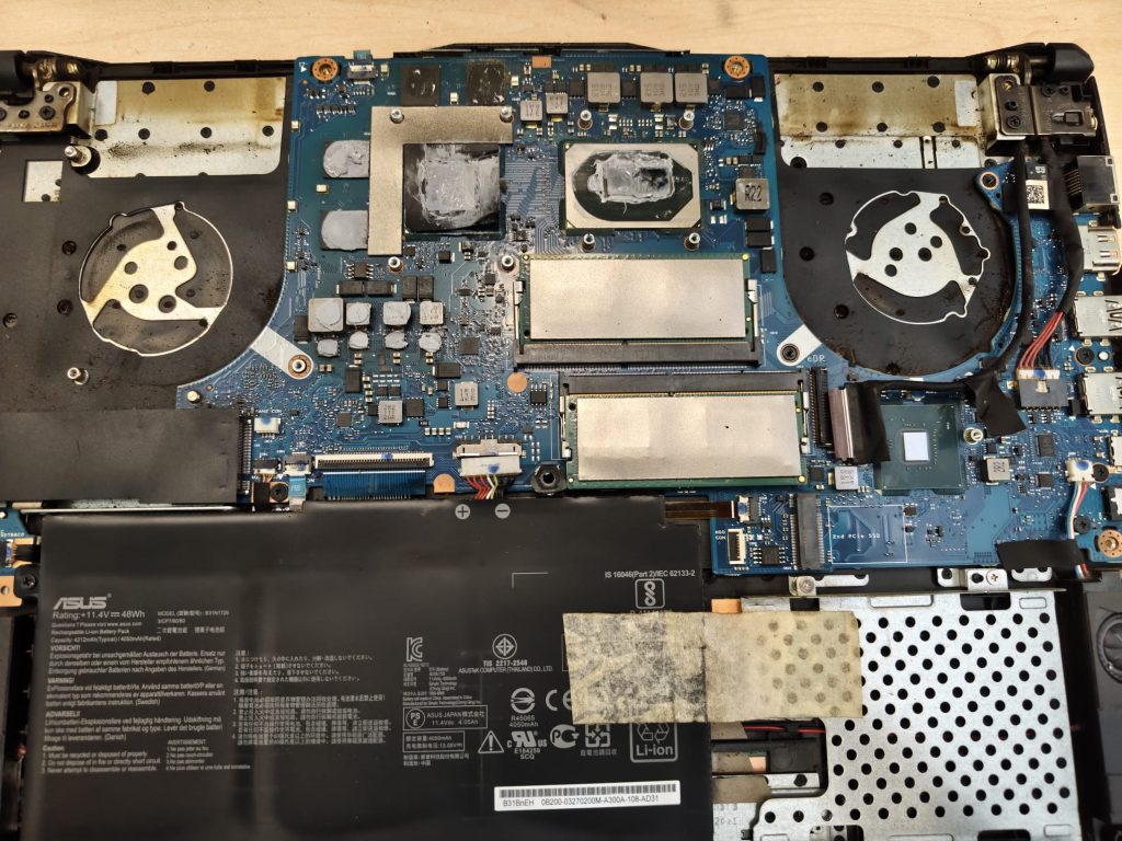 Vista interna de placa base ASUS TUF Gaming F15 con pasta térmica seca en procesador y gráfica.